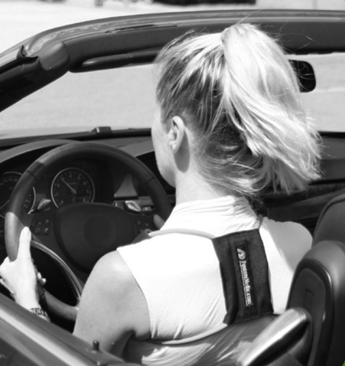 Woman wearing a Posture Medic posture corrector while driving. 